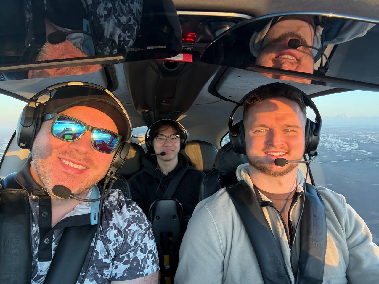 Dawson Gant in the cockpit of a private aircraft at golden hour with aviation headsets on